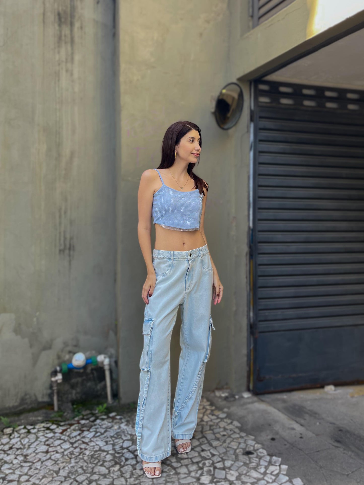 Calça jeans lavagem clara com bolsos laterais e detalhe