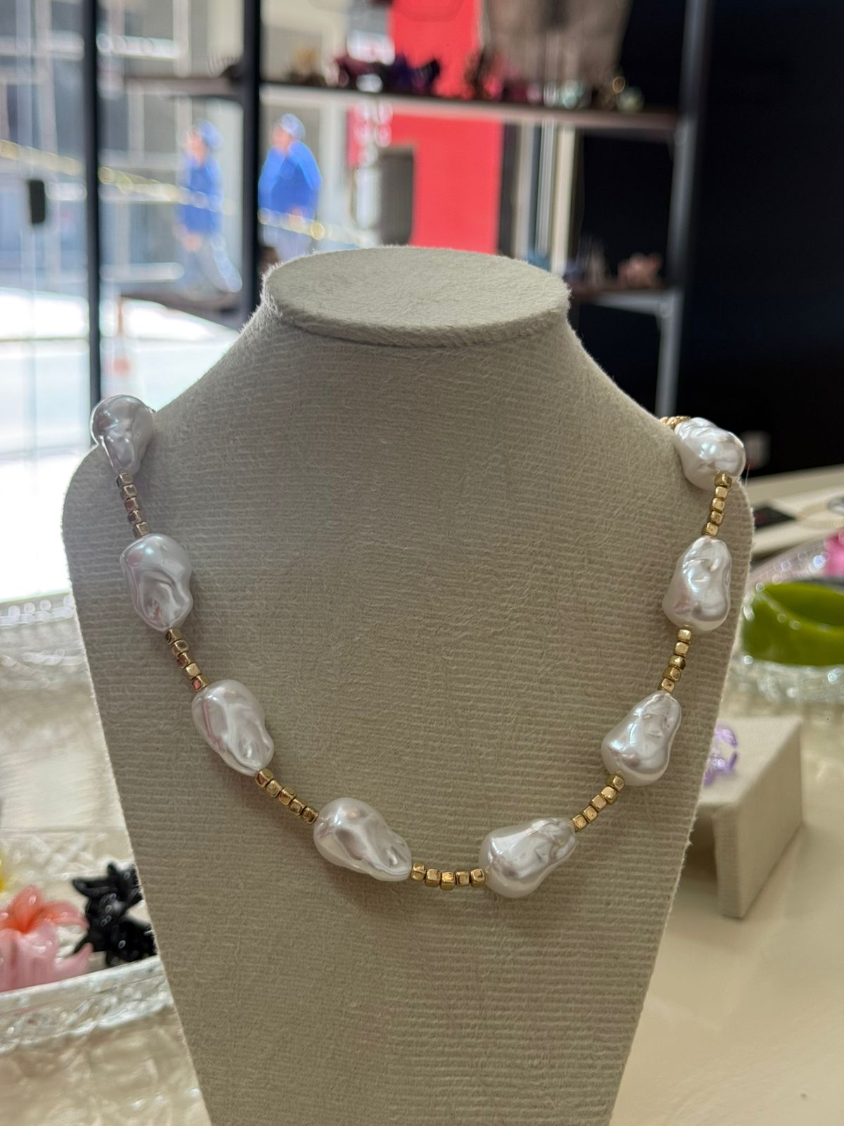 Colar de pérolas irregulares com detalhe dourado