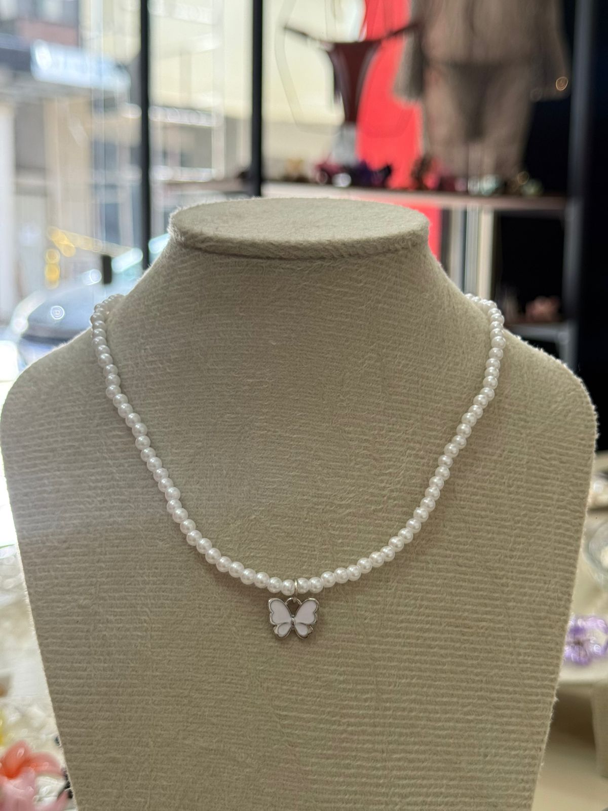 Colar de pérolas com pingente de borboleta