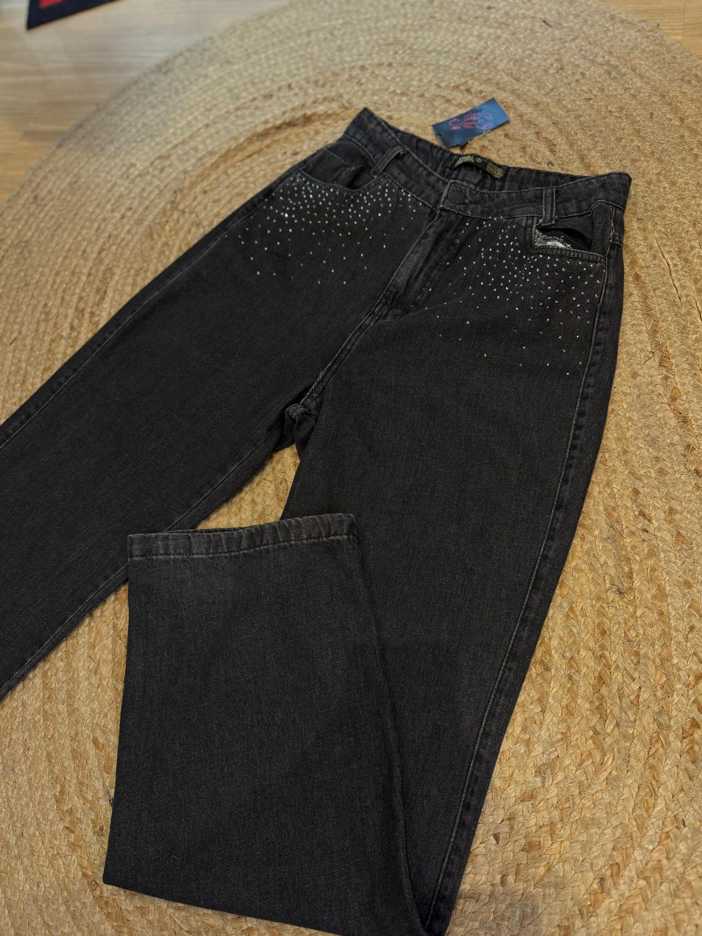 Calça jeans estonada com strass na frente