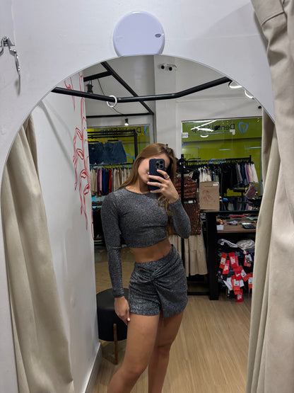 Conjunto de shorts saia e cropped com manga longa de lurex
