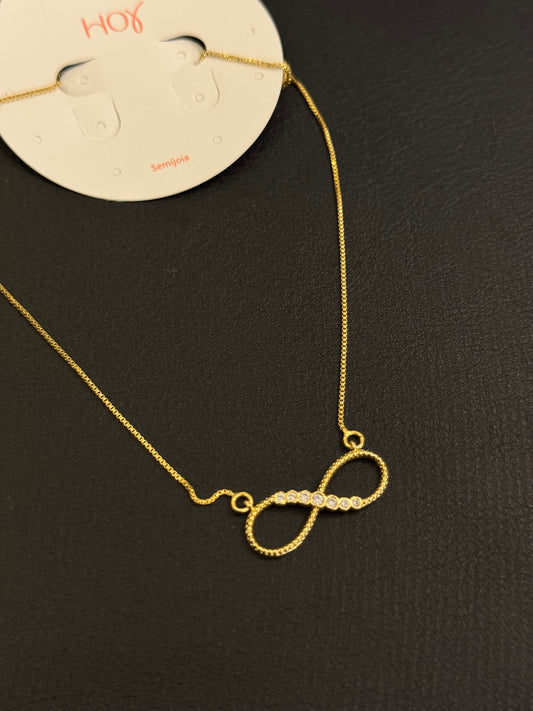 Colar dourado com símbolo do infinito e detalhes em strass